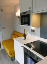 CONTENEDOR TRANSFORMADO EN CASA PORTÁTIL CON MUEBLES DE JARDÍN